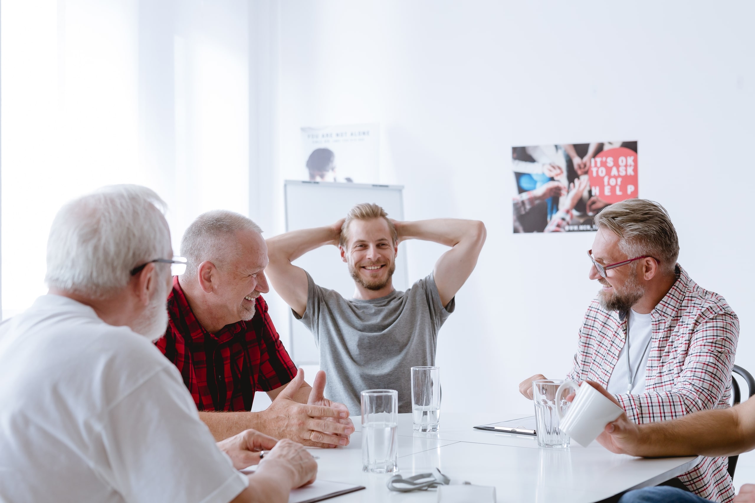 Grupo de hombres de diferentes edades participando en una terapia grupal, representando cómo el trauma afecta a diferentes grupos demográficos y subrayando la importancia del apoyo comunitario en el proceso de recuperación.